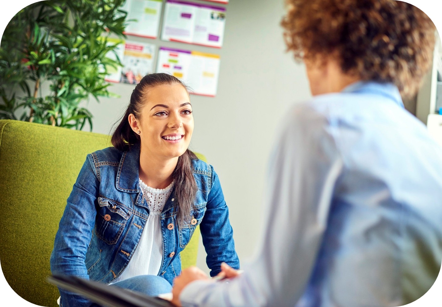 Photograph of two people engaged in a conversation in an office setting.