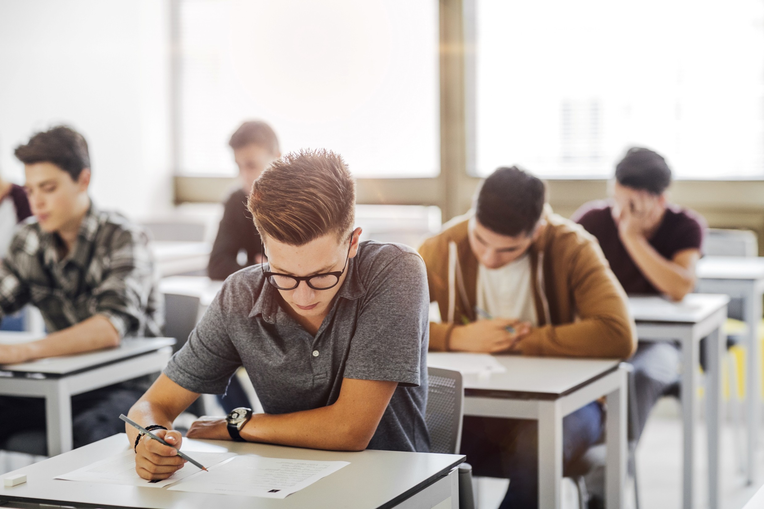 Students seated at individual desks, focused on an exam in a classroom
